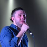 Тарас Тополя поет на сцене с микрофоном